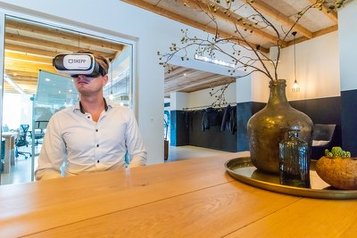 Usuario con gafas de realidad virtual en un recorrido por una oficina virtual de forma remota con SKEPP